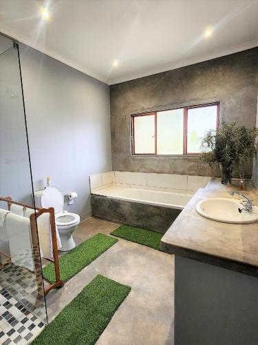 a bathroom with a tub and a toilet and a sink at Serena Cottage in Nottingham Road