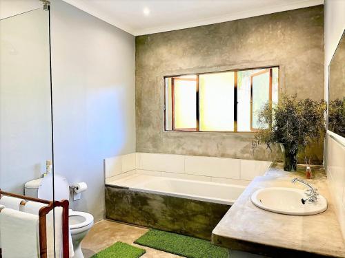 un bagno con vasca, WC e lavandino di Serena Cottage a Nottingham Road