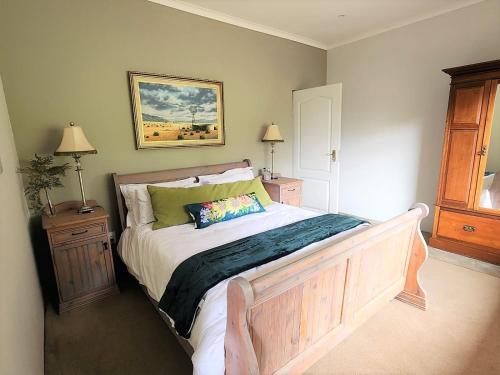 una camera da letto con un letto con due comodini e due lampade di Serena Cottage a Nottingham Road