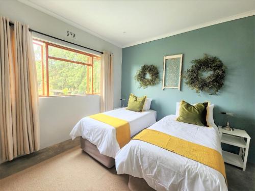 a bedroom with two beds and a window at Serena Cottage in Nottingham Road