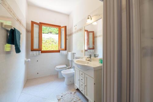 a bathroom with a sink and a toilet and a window at Casa Luppoli in Portoferraio