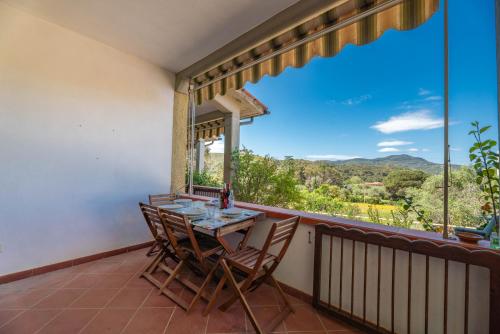 a balcony with a table and chairs and a large window at Casa Luppoli in Portoferraio