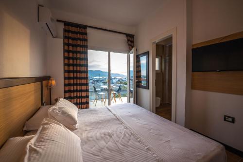 a bedroom with a bed with a view of a balcony at Inada Rooms Ksamil in Ksamil