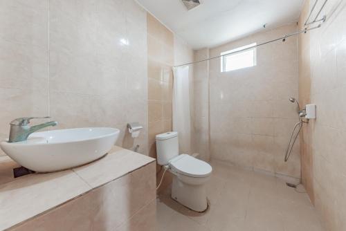 a white bathroom with a sink and a toilet at Urbanview Hotel Onyx Ketapang by RedDoorz in Ketapang