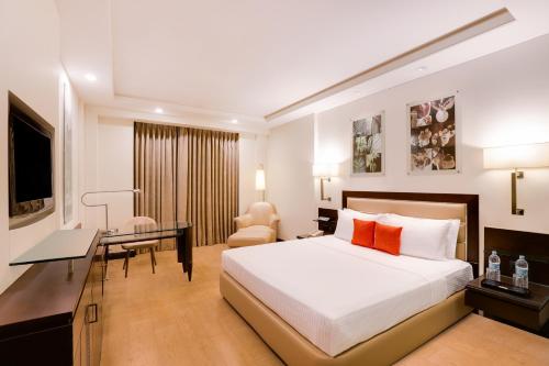 a hotel room with a bed and a desk at Lemon Tree Premier 2, Gurugram in Gurgaon