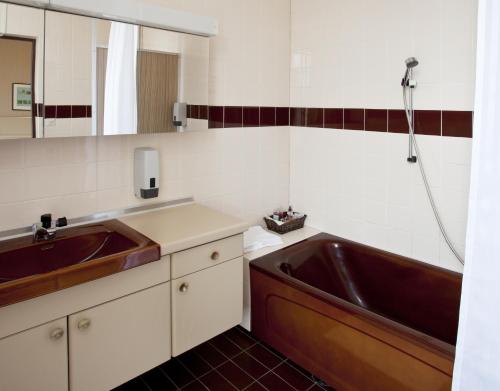 uma casa de banho com um lavatório e uma banheira em Hotelli-Ravintola Mäntän Klubi em Mänttä