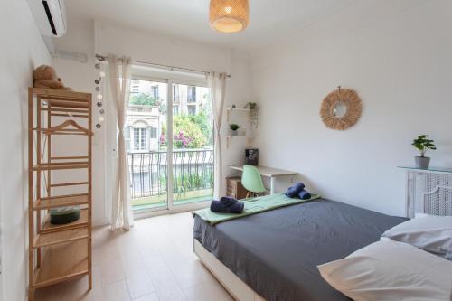 - une chambre avec un lit et une porte donnant sur un balcon dans l'établissement 26 nice , La Riviera, à Nice
