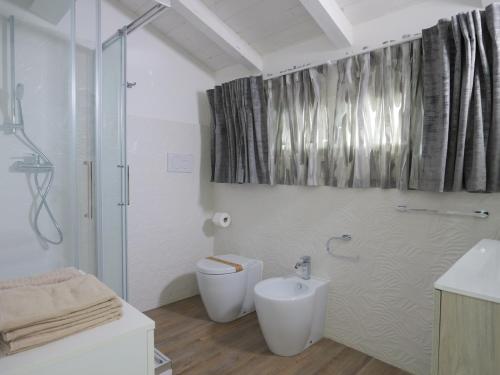 bagno bianco con servizi igienici e doccia di Palma Residence - Villino LA QUERCIA a Marco Simone