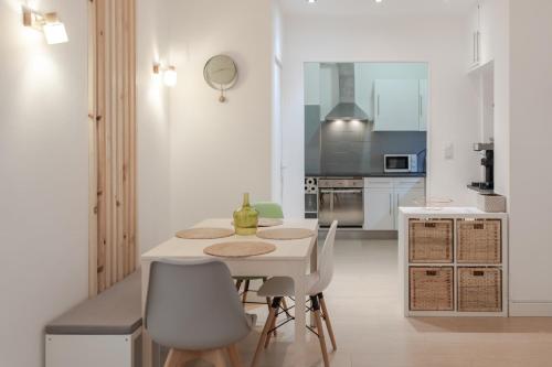 une cuisine blanche avec une table et des chaises dans l'établissement 26 nice , La Riviera, à Nice