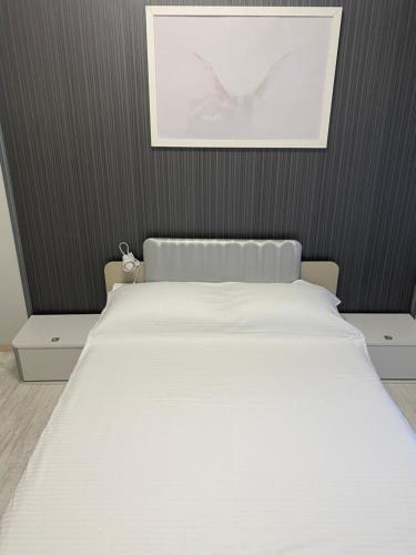 a white bed in a room with a picture on the wall at Iva Luxury Apartament in Ruse