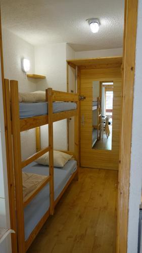 a room with three bunk beds and a mirror at Résidence Alpinéa Mottaret, 2 à 4 pers in Méribel