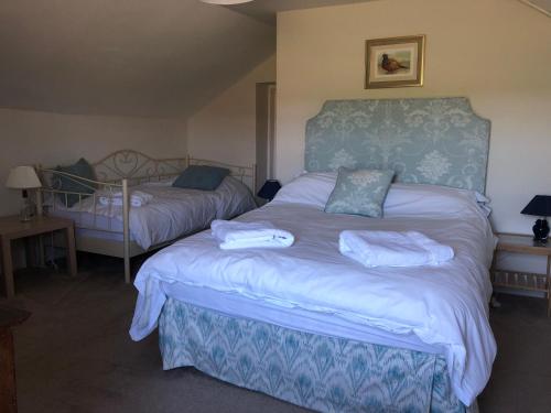 a bedroom with two beds with towels on them at Laundry Cottage in Dumfries