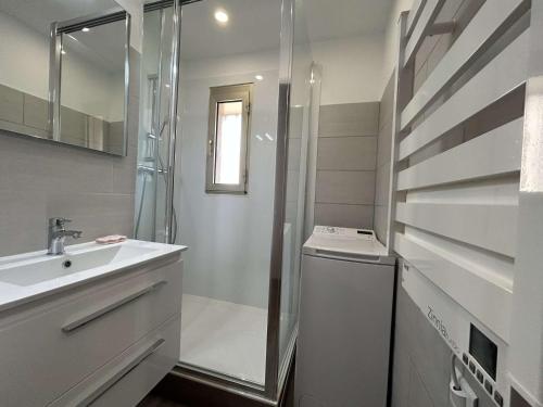 une salle de bain blanche avec une douche et un lavabo dans l'établissement Appartement à Sainte-Maxime: 3 Pièces, Terrasse, Piscine, Clim, Proche Plage - FR-1-226-340, à Sainte-Maxime