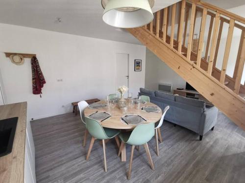 une salle à manger avec une table et un escalier dans l'établissement Soulac-sur-Mer T4 hypercentre proche mer, à Soulac-sur-Mer