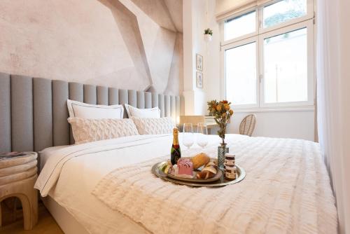 een dienblad met eten op een bed met een fles champagne bij The Bohemian Courtyard Studios in Wenen