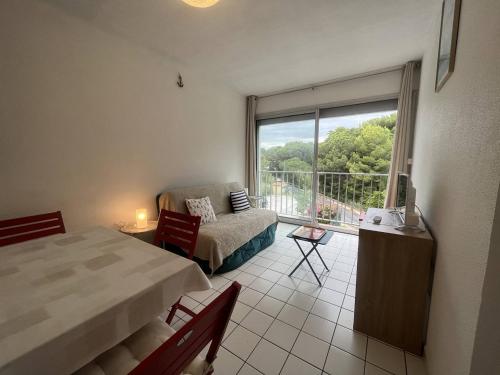 une chambre avec un lit et une vue sur un balcon dans l'établissement Studio cabine pour 4 pers, proche plage, animaux admis - Saint-Cyprien - FR-1-106-91, à Saint-Cyprien