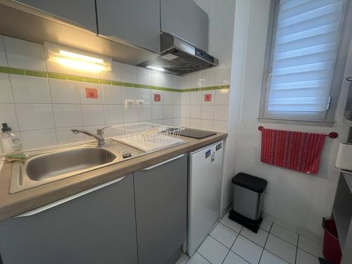 une petite cuisine avec un évier et une fenêtre dans l'établissement Studio cabine pour 4 pers, proche plage, animaux admis - Saint-Cyprien - FR-1-106-91, à Saint-Cyprien