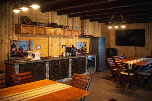 comedor con paredes de madera, mesas y sillas en Glamping La Octav en Tîrpeşti