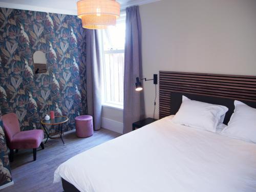 - une chambre avec un lit, une chaise et une fenêtre dans l'établissement ‘t Wirdummer Hof - family-friendly guesthouse, à Wirdum