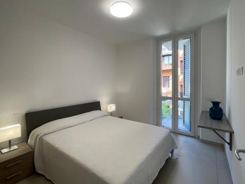 a white bedroom with a bed and a window at Carissimi 4 in Milan