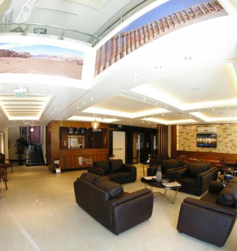 a lobby with couches and chairs and a staircase at Ream Hotel Amman in Amman