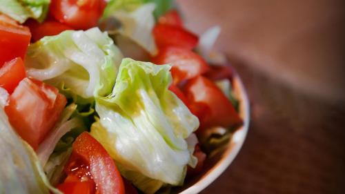 a bowl of salad with lettuce and tomatoes on a table at Holiday Inn Jacksonville E 295 Baymeadows by IHG in Jacksonville