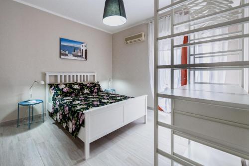 a white bedroom with a bed and a window at Bacicagiuba Apartments in Termini Imerese