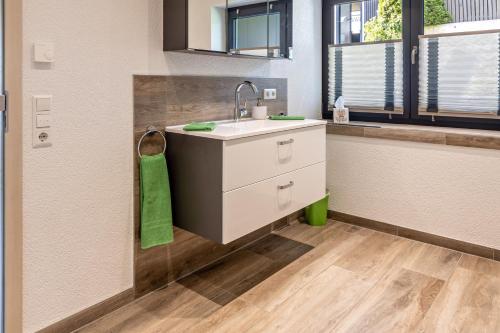 a bathroom with a sink and a green towel at Am oberen Bühl in Furtwangen