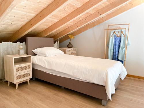 a bedroom with a large bed and a wooden ceiling at Salthouse Portugal - Stylish Duplex Apartment in Aljezur