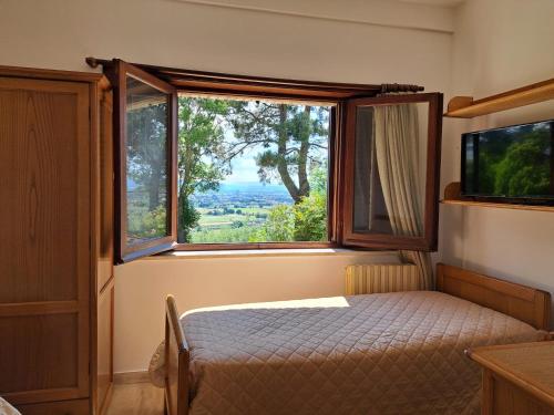 a bedroom with a bed and a large window at Casa per Ferie Ulivo d'Assisi in Assisi