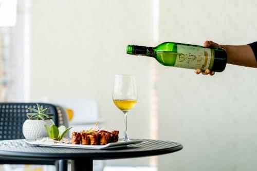 a person pouring a glass of wine over a table at Dreamland Gold Resort & Hotel in Bhairāhawā