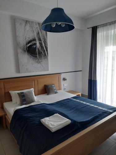 a bedroom with a large bed with a blue blanket at Hédervári Lovas Vendégház in Hédervár