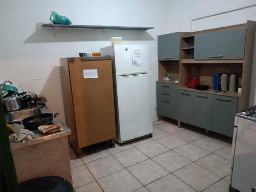 uma cozinha com um frigorífico branco e armários cinzentos em Mansão Akkui Hostel em São Paulo