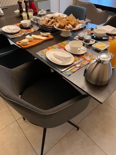 una mesa con platos y comida. en Ancien Haras de la Tour, en Lamothe-Landerron