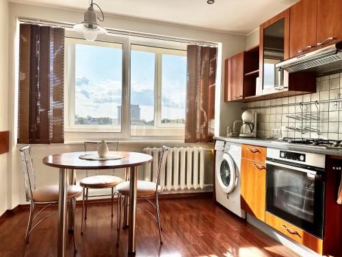 une cuisine avec une table et des chaises ainsi qu'une fenêtre dans l'établissement Central, à Panevėžys