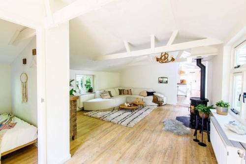 ein Wohnzimmer mit weißen Wänden und Holzböden in der Unterkunft Rustgevend Paradijs aan het Bos in Putten