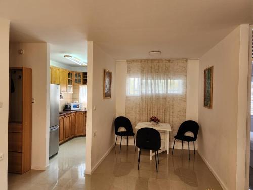 a kitchen with a table with chairs and a refrigerator at Краткосрочная посуточная аренда Бат-Ям! in Bat Yam