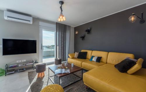 a living room with a yellow couch and a tv at Penthouse Novigrad by SeeAdria Agency in Novigrad Istria