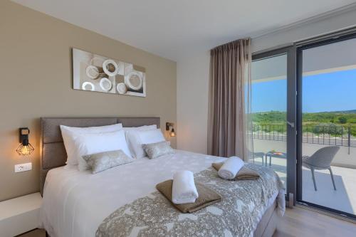 a bedroom with a large bed and a balcony at Villa Chiara by SeeAdria Agency in Brtonigla