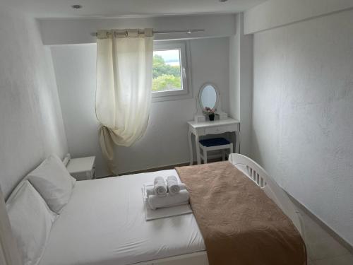 a white bedroom with a bed and a mirror at Astri Villa in Ierissos