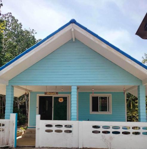 a blue house with a white fence in front of it at Baan Namthip Homestay Trang บ้านน้าทิพย์ โฮมสเตย์ตรัง in Ban Huai To (1)