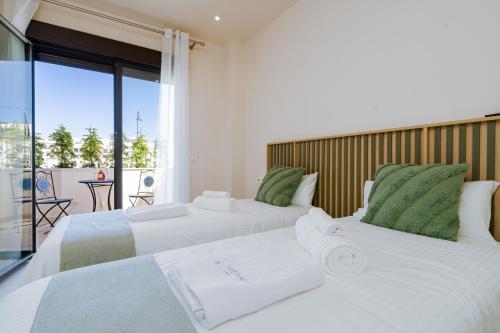 two white beds in a room with a balcony at Jardinana - apartment with two bedrooms close to beach and town center in La Cala de Mijas