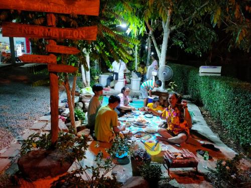 a group of people sitting around a picnic table at Baan Namthip Homestay Trang บ้านน้าทิพย์ โฮมสเตย์ตรัง in Ban Huai To (1)