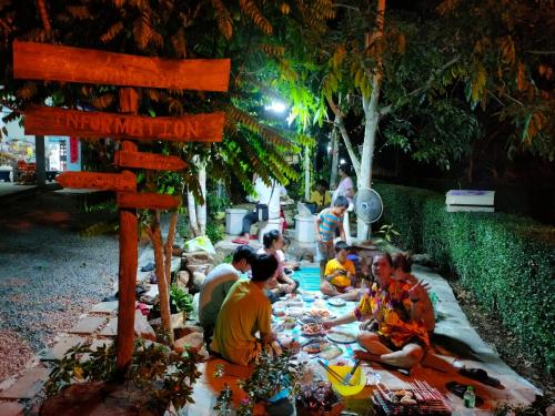 a group of people sitting around a picnic table at Baan Namthip Homestay Trang บ้านน้าทิพย์ โฮมสเตย์ตรัง in Ban Huai To (1)