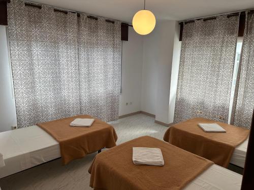 a room with two beds and two tables with towels at PENSIÓN LA HACIENDA in Padrón