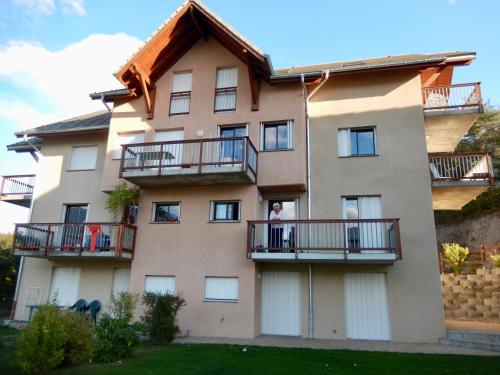 a building with balconies and people standing on them at Appartement Savines-le-lac, aan het meer van Serre-Ponçon te huur per week van zaterdag tot zaterdag par semaine complète de samedi à samedi in Savines