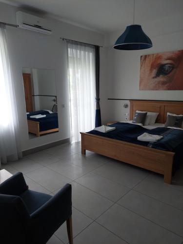 a bedroom with a bed and a mirror and a chair at Hédervári Lovas Vendégház in Hédervár