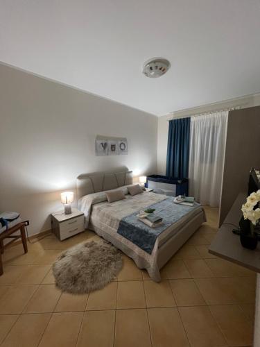 サン・ヴィート・ロ・カーポにあるappartamento residence via giardini Acquamarinaのベッドルーム1室(大型ベッド1台、ラグ付)