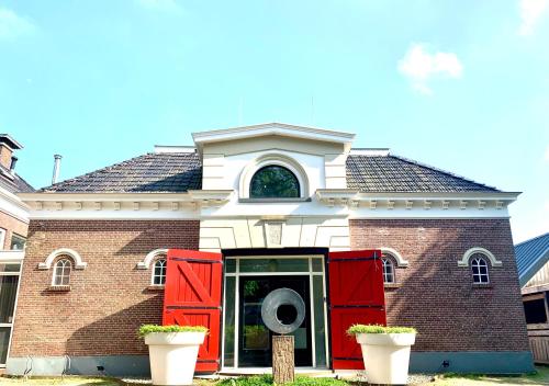 a red and white house with red doors at ‘t Wirdummer Hof - family-friendly guesthouse in Wirdum