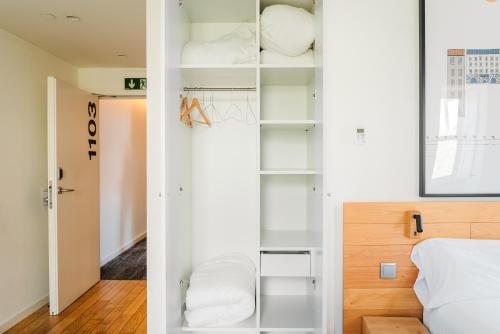 una camera da letto con armadio, scaffali bianchi e letto di The Central House Porto Ribeira a Porto
